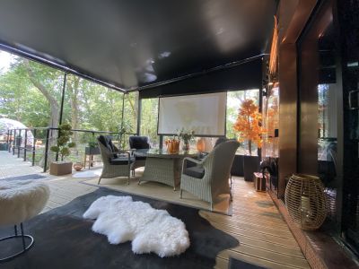 The Copper Cabin Exterior with seating and Cinema Screen