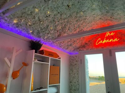 The Cabana Beach Hut interior flower ceiling with neon sign