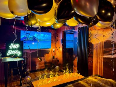 The Cave with Happy Birthday Neon sign, x20 ceiling balloons and fire wall